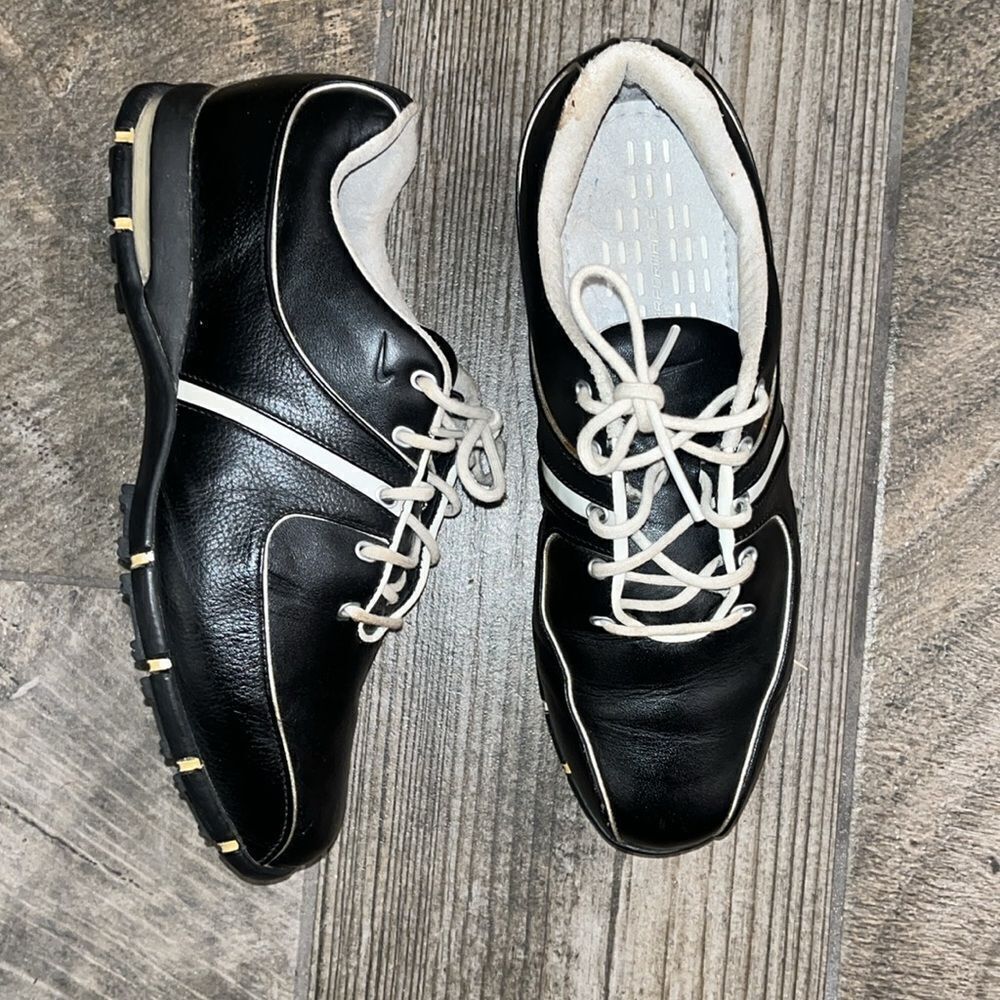 Nike Air TAC black leather golf shoes, sports performance.